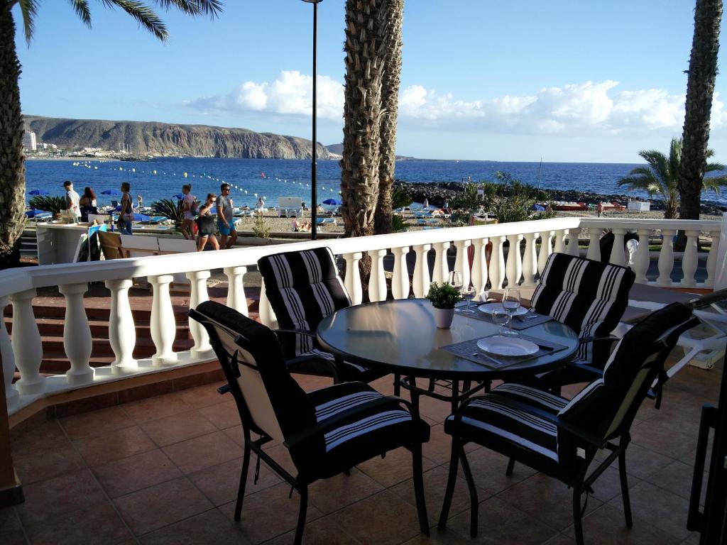 阿罗纳PRIMERA LINEA DE PLAYA的俯瞰大海的阳台配有桌椅