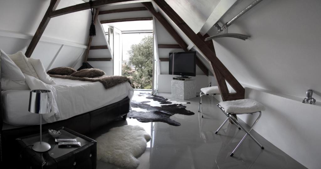 维里天堂套房酒店的一间卧室配有一张床和一台电视。