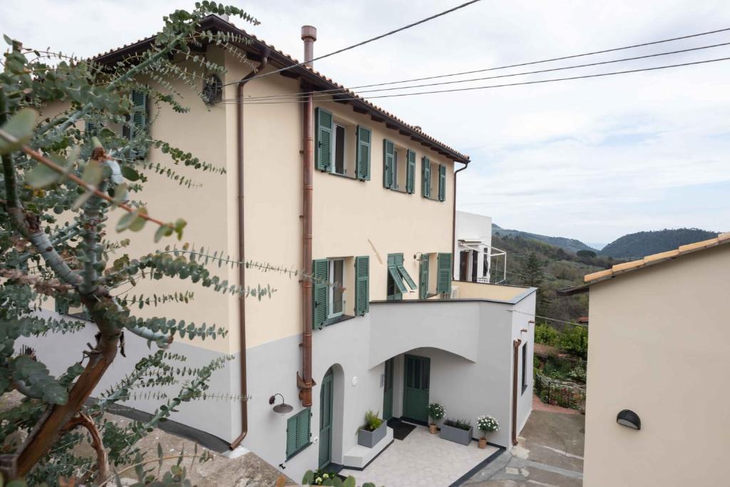 Bardino VecchioAgriturismo Ca Du Briccu的山上的白色房子,设有绿色百叶窗