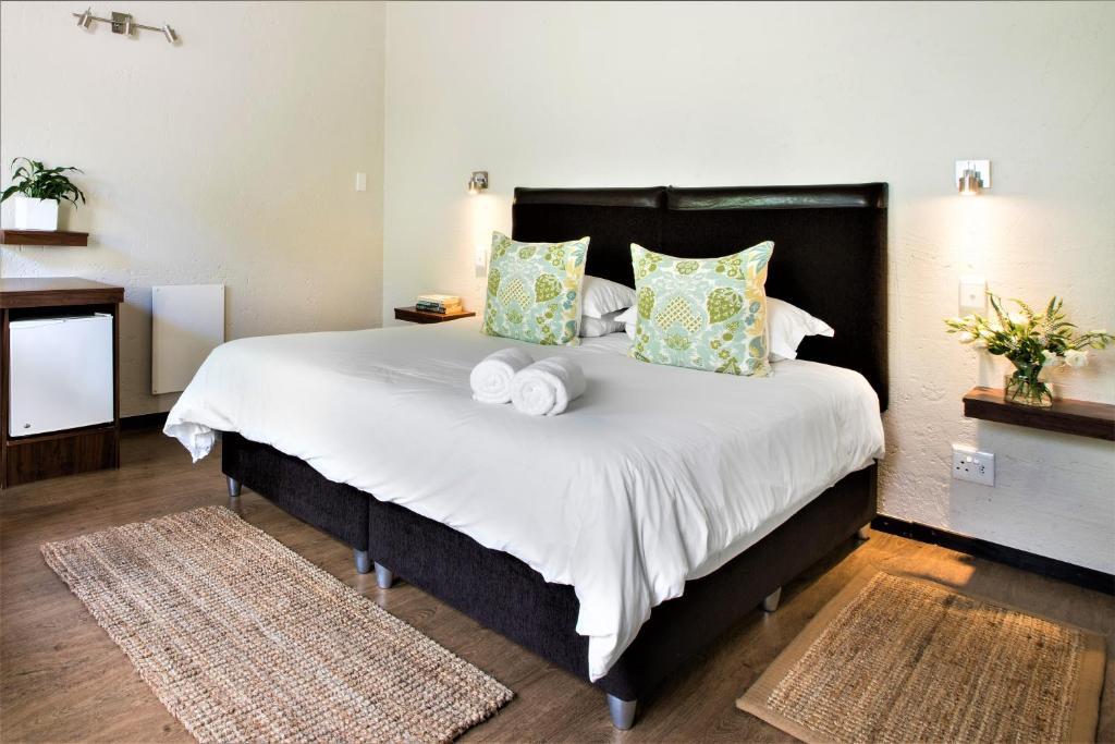 约翰内斯堡Sandton Slippers的一间卧室配有一张大床和两条毛巾