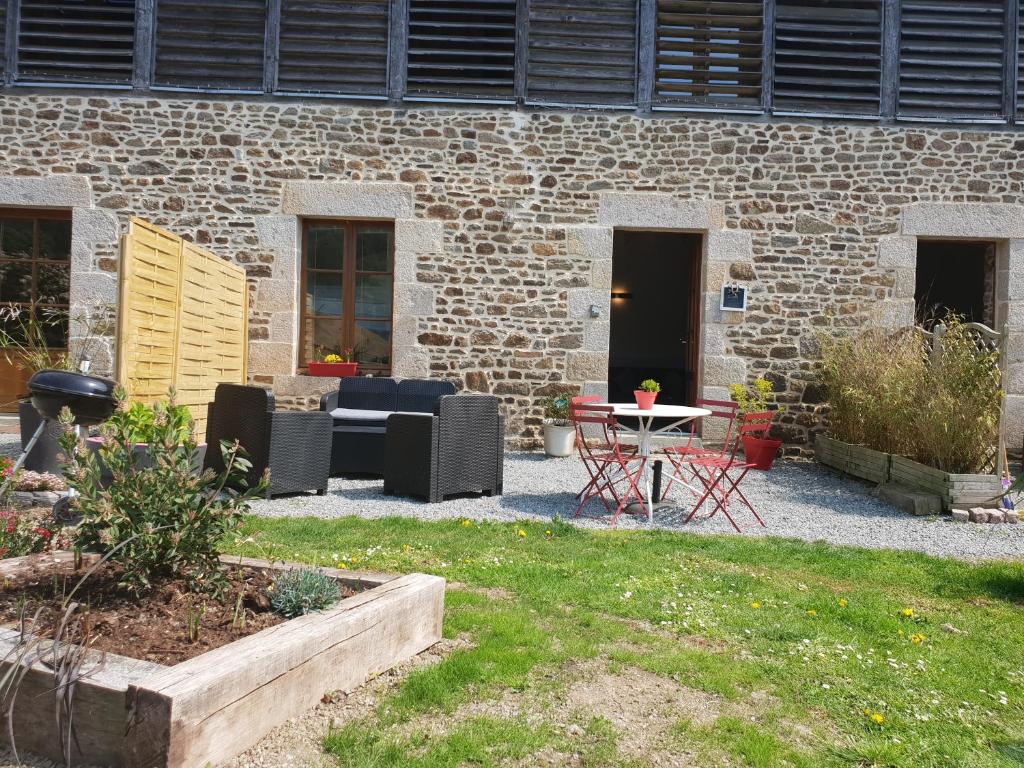 迪南Gite de la tannerie 3的砖砌建筑前带桌椅的庭院