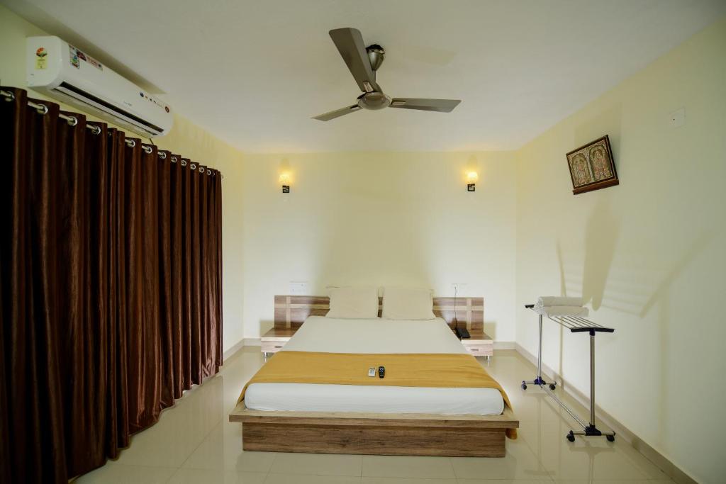 SubrahmanyaShesha KUTEERA的一间卧室配有一张床和吊扇