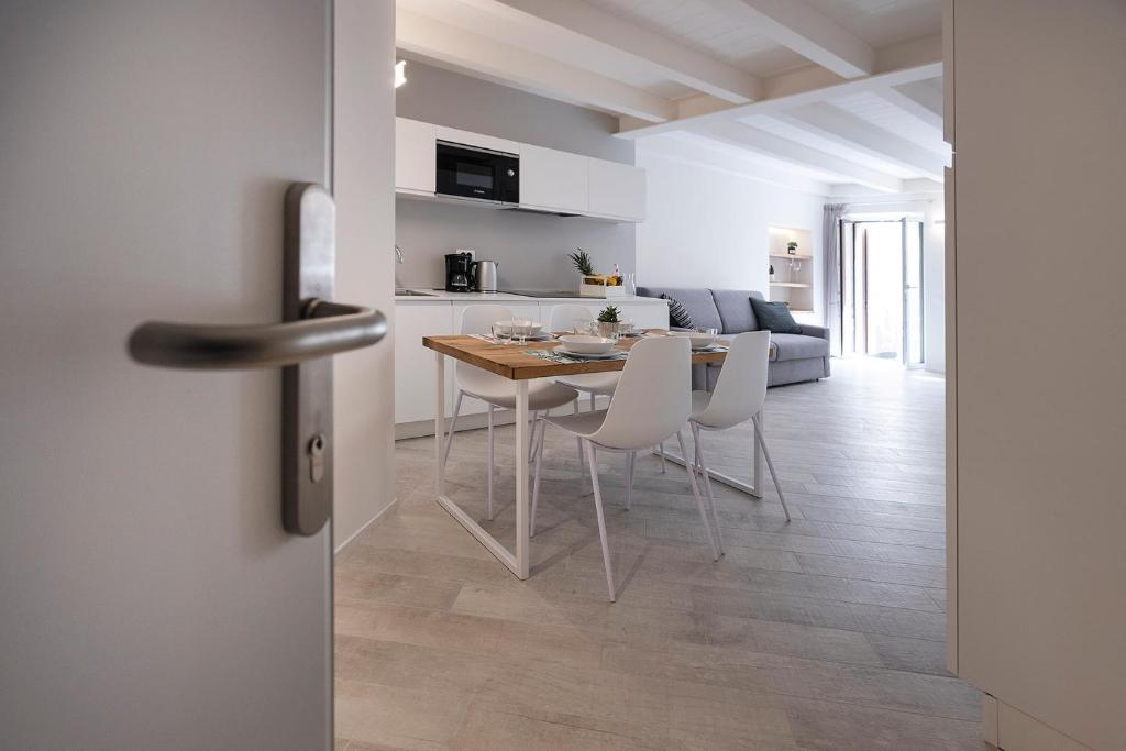 马尔切西内Picalof Apartments的厨房以及带桌椅的起居室。
