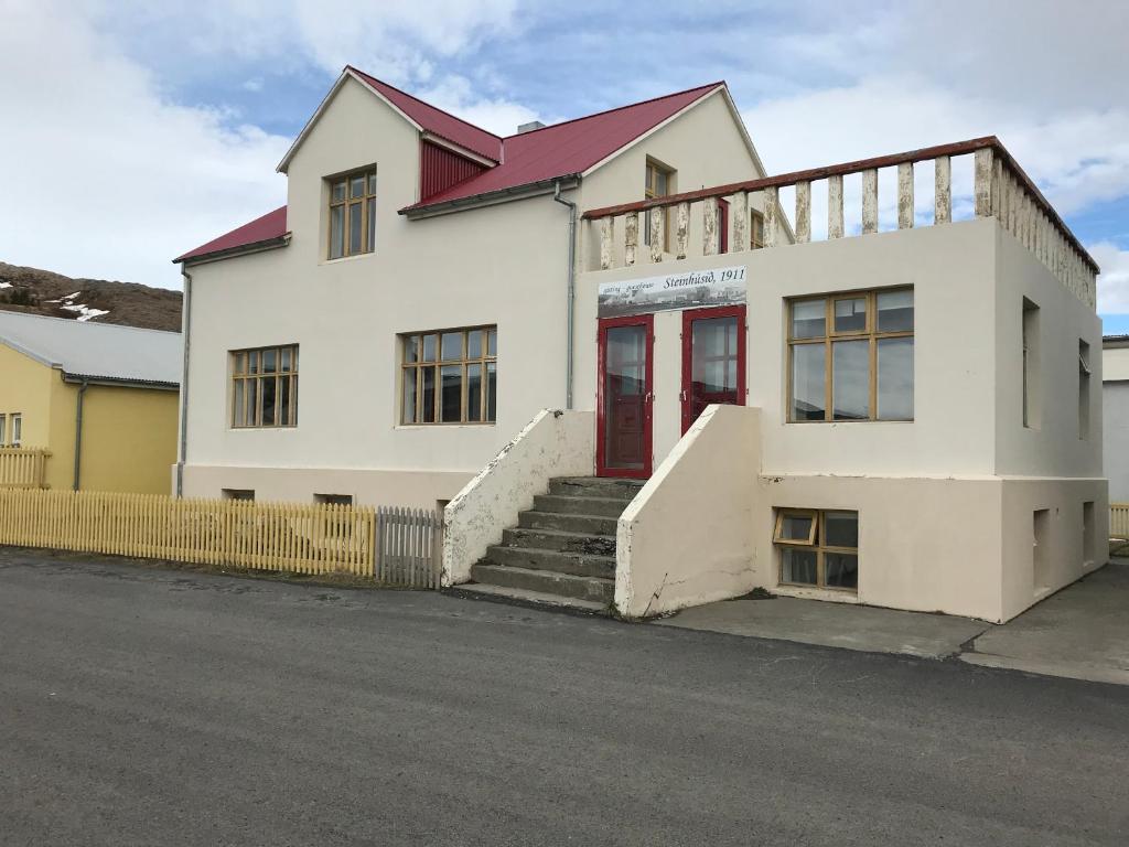 侯尔马维克Steinhúsið的街上有红色门的白色建筑