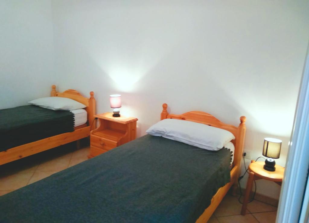莱乌卡Casa vacanza Leuca的一间卧室设有两张床和两张台灯。