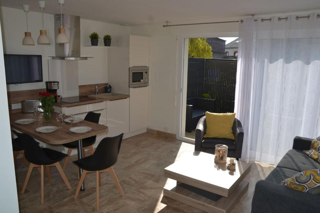 朗代尔诺Résidence Bel Air的厨房以及带桌椅的起居室。