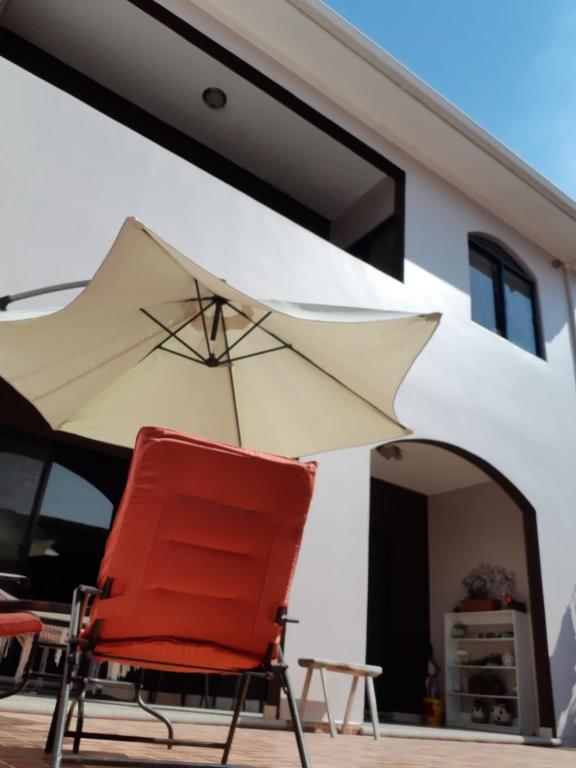 特古西加尔巴Casa Sur的房屋前的红椅和雨伞