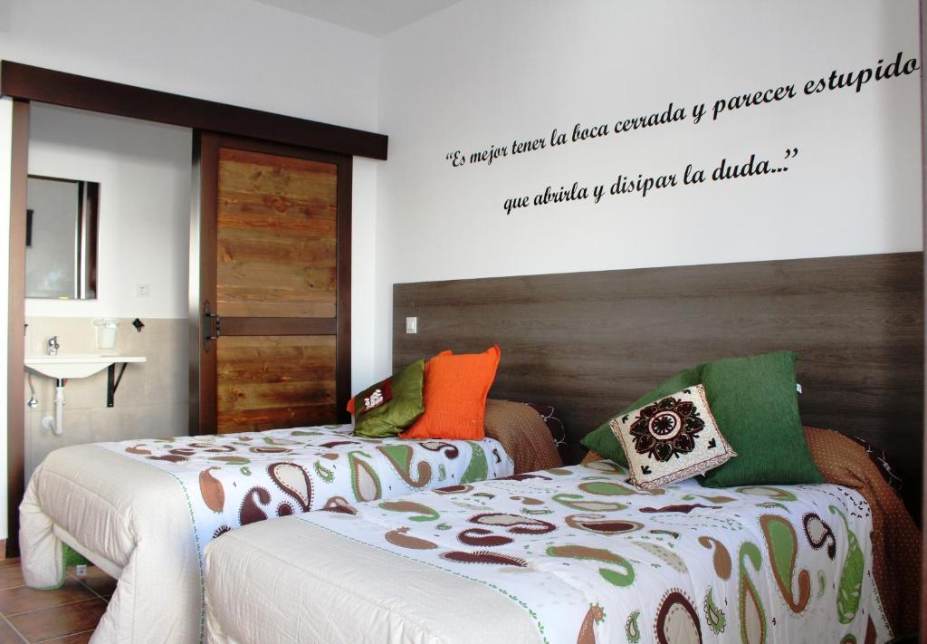 阿尔玛格鲁Hostal Almagro的卧室配有两张床,墙上有标志