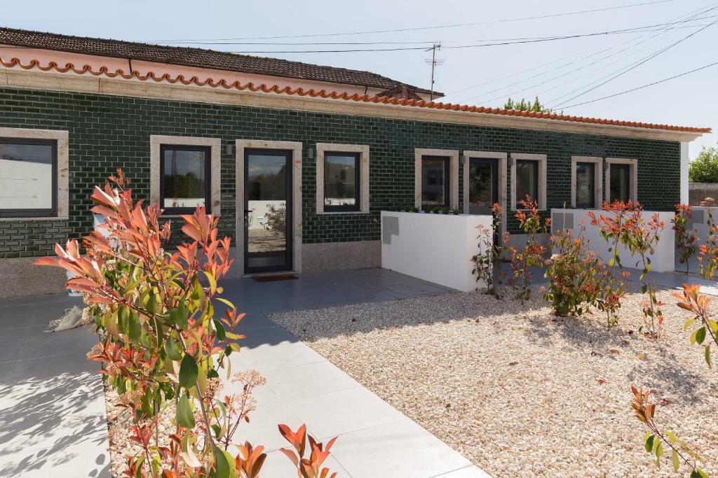 贡多马尔Green Villas Douro的一座绿色砖屋,前面设有花园