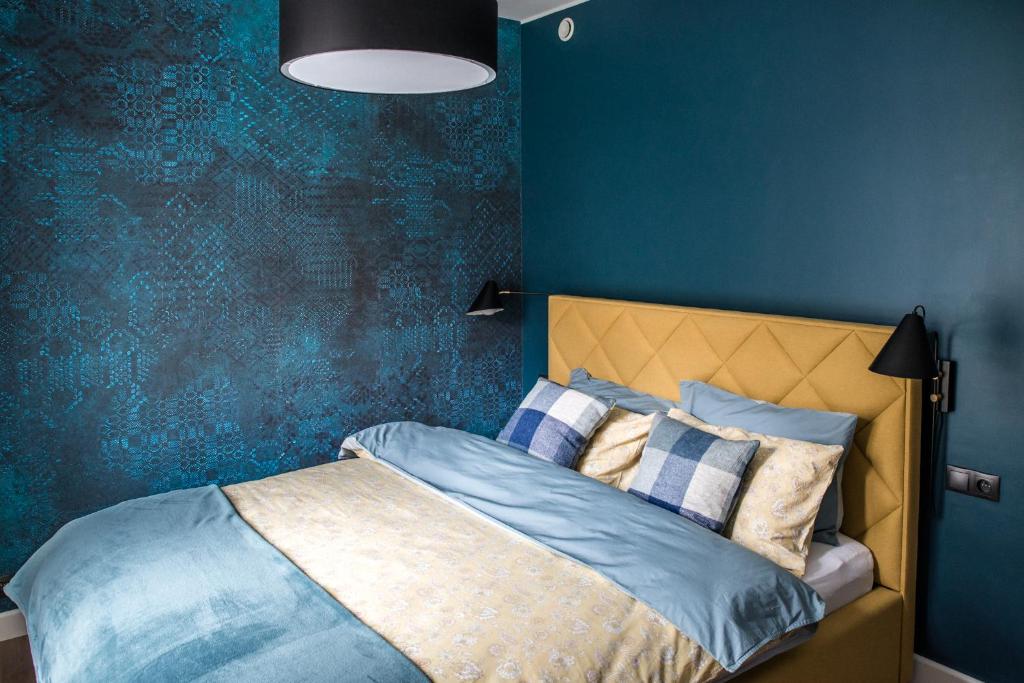 克拉科夫Augustiańska的一间卧室配有一张蓝色墙壁的床