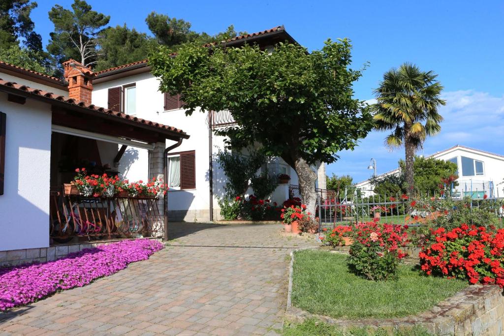 波尔托罗Sea View Apartments Portoroz ZM的庭院里鲜花盛开的房子