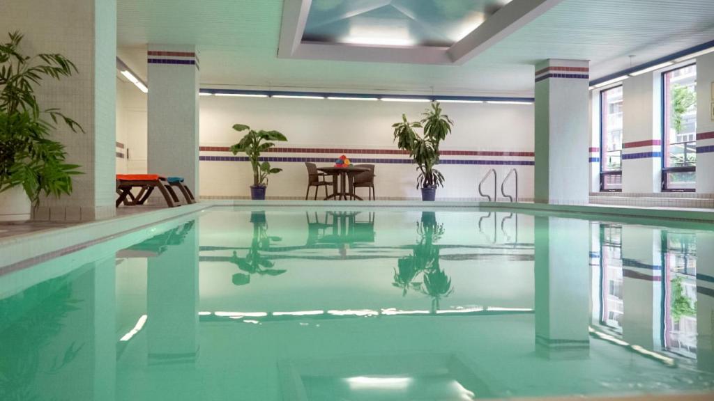 渥太华卡地亚套房酒店 的一座带桌子的建筑中的游泳池