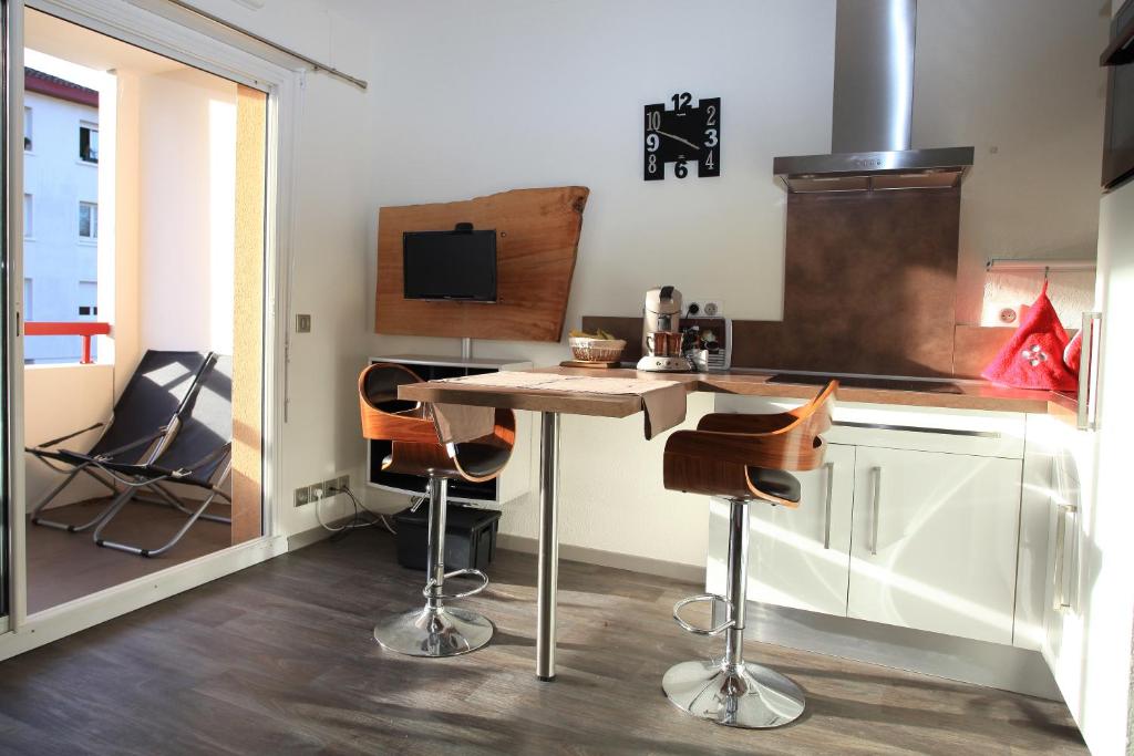 康博莱班Studio Ttikia的厨房配有桌子和酒吧凳