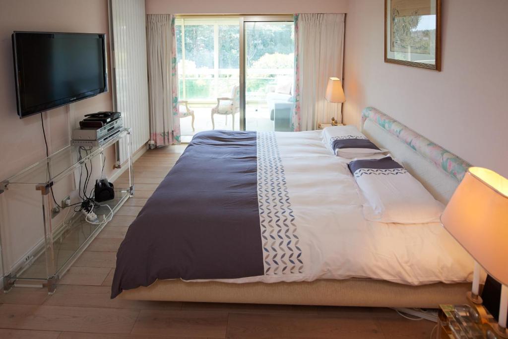 戛纳Appartement Luxueux 150m2 - Cannes的一间卧室配有一张大床和电视
