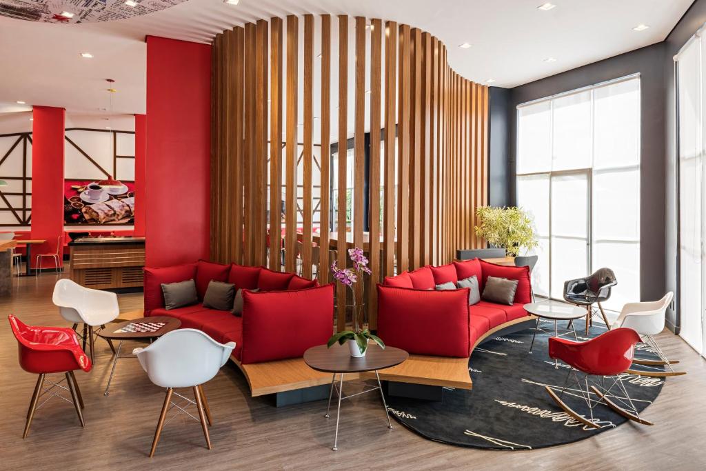 布卢梅瑙ibis Blumenau的客厅配有红色沙发和白色椅子