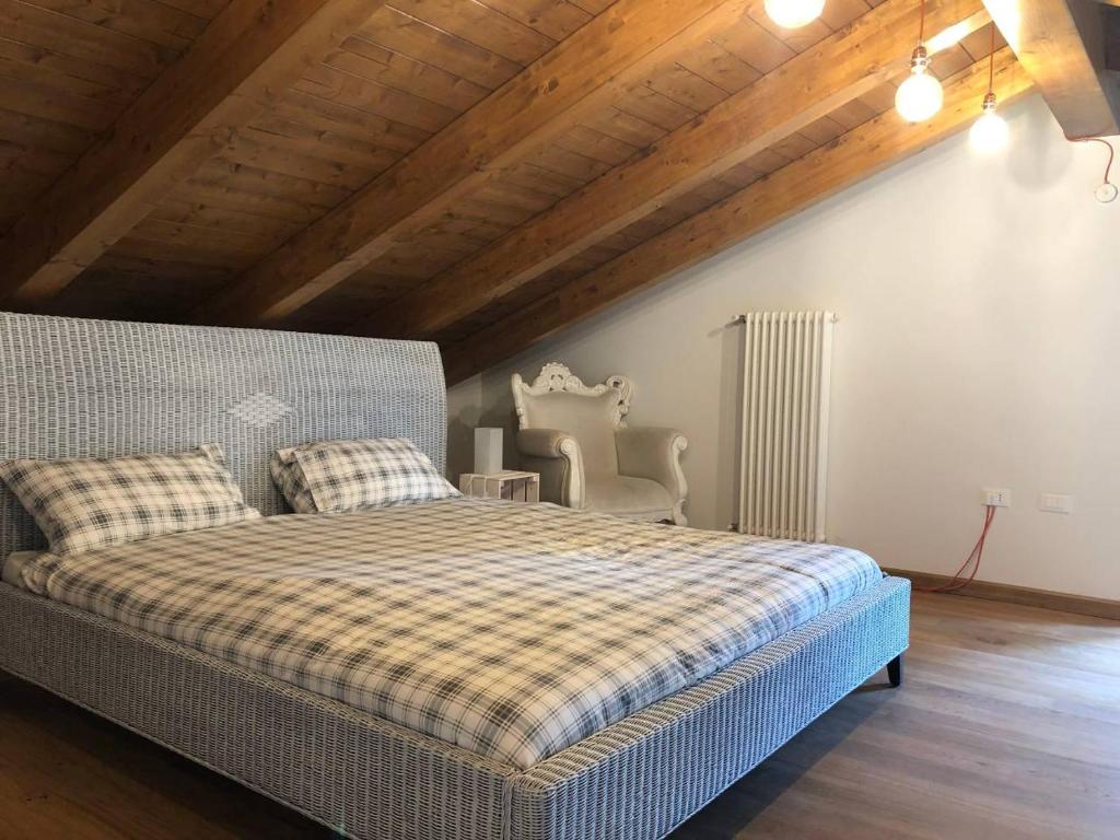 皮内罗洛Casa di Miele的一间卧室设有一张床和木制天花板