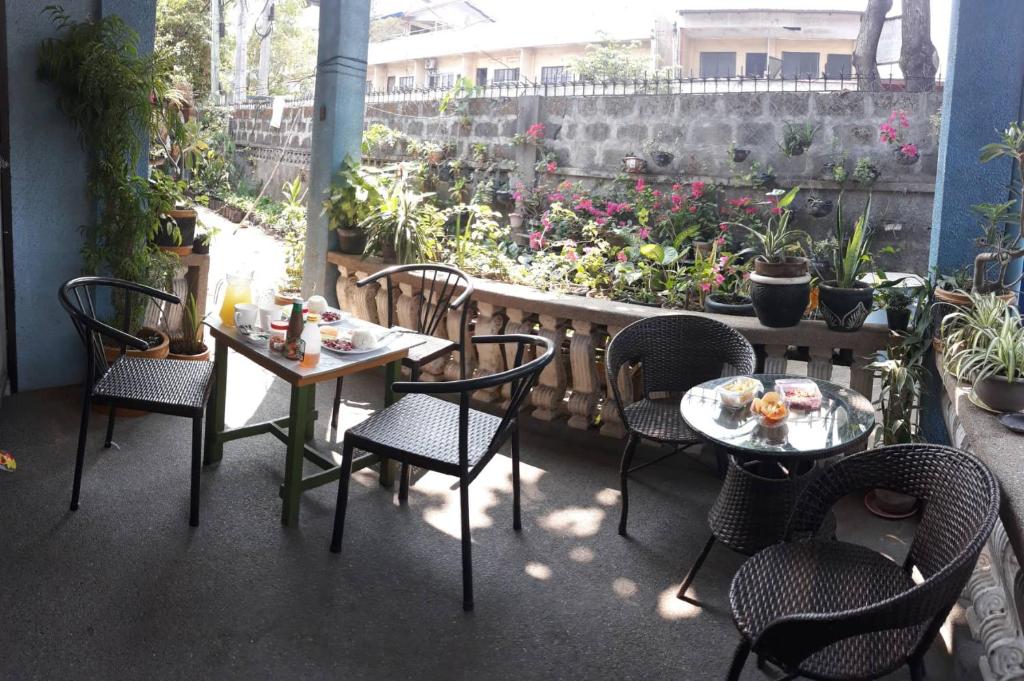 Dalumpinas Oestecv bed n bath san juan的一个带桌椅的庭院和一个花园