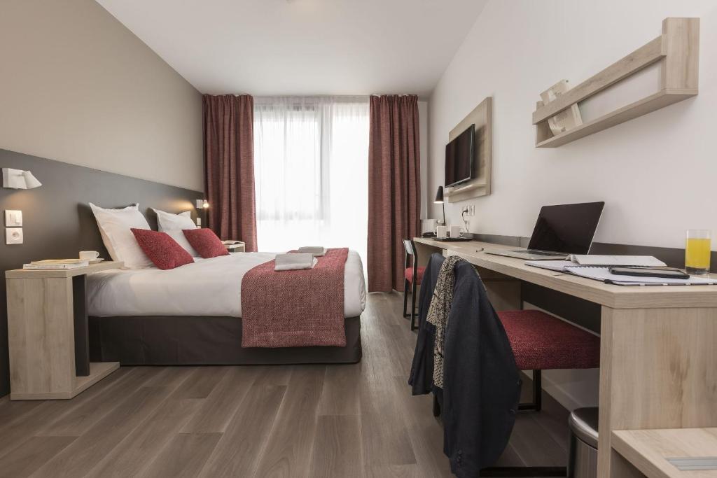 勒芒Odalys City Le Mans Centre Congrès的配有一张床和一张书桌的酒店客房