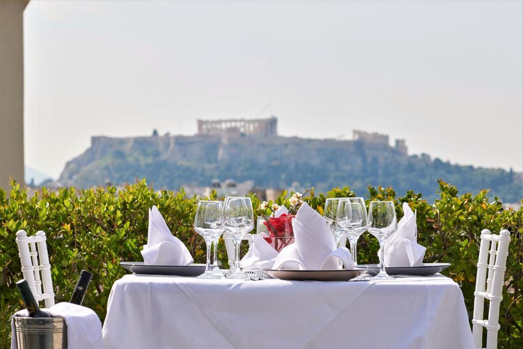 雅典水晶之城酒店的一张带酒杯和餐巾的白色桌子