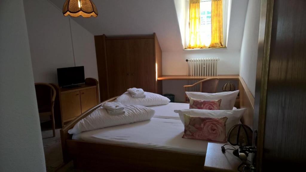 吕德斯海姆索马山酒店的一间卧室配有带白色床单和枕头的床。