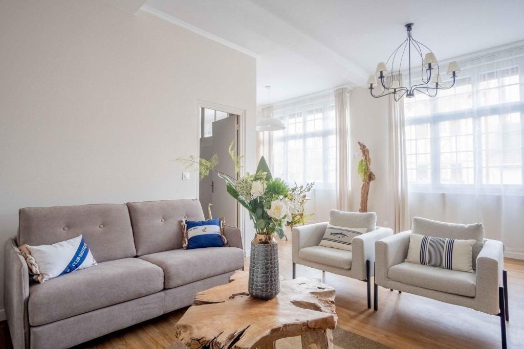 卡布尔Elégant appartement en plein coeur de Cabourg - Les locations de Proust的客厅配有沙发、两把椅子和一张桌子