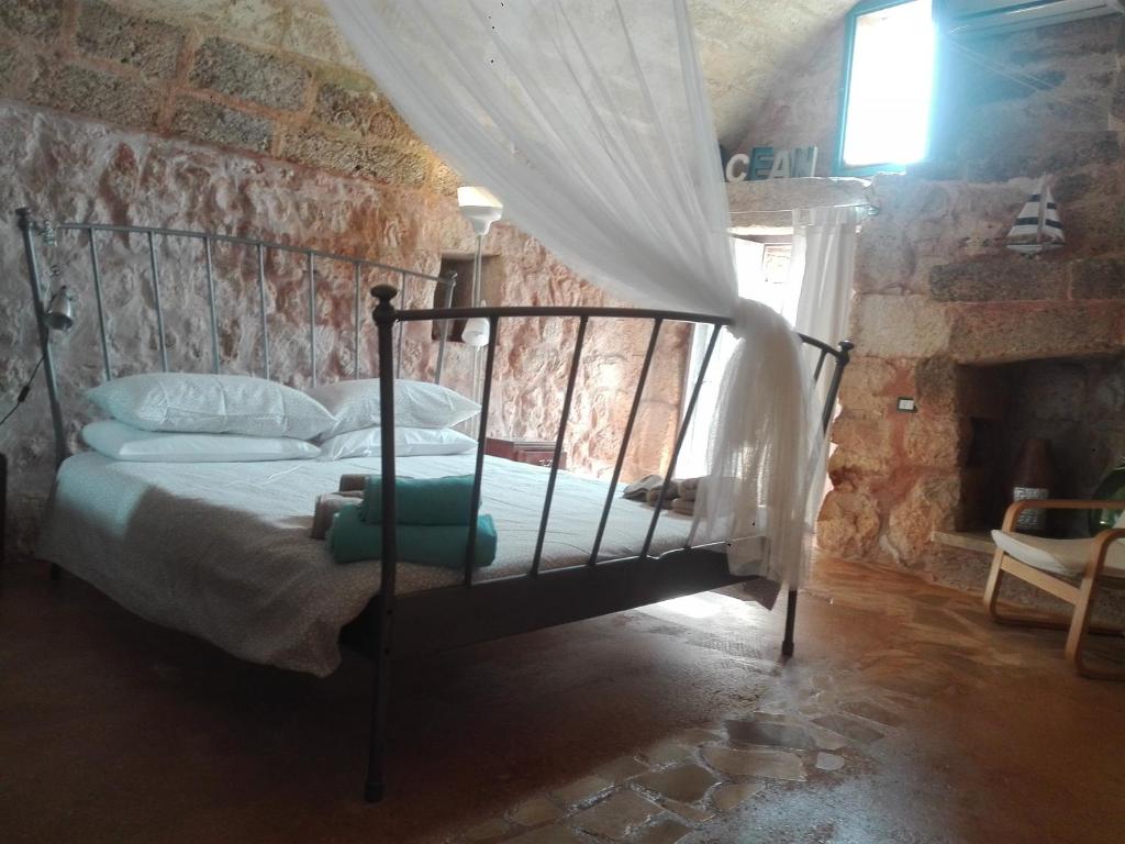 卡斯特里尼亚诺德尔卡波Trullo Nicola的卧室配有砖墙内的床铺