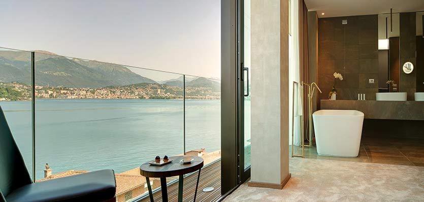 坎皮奥内Grand Hotel Campione的享有水景并配有浴缸的浴室