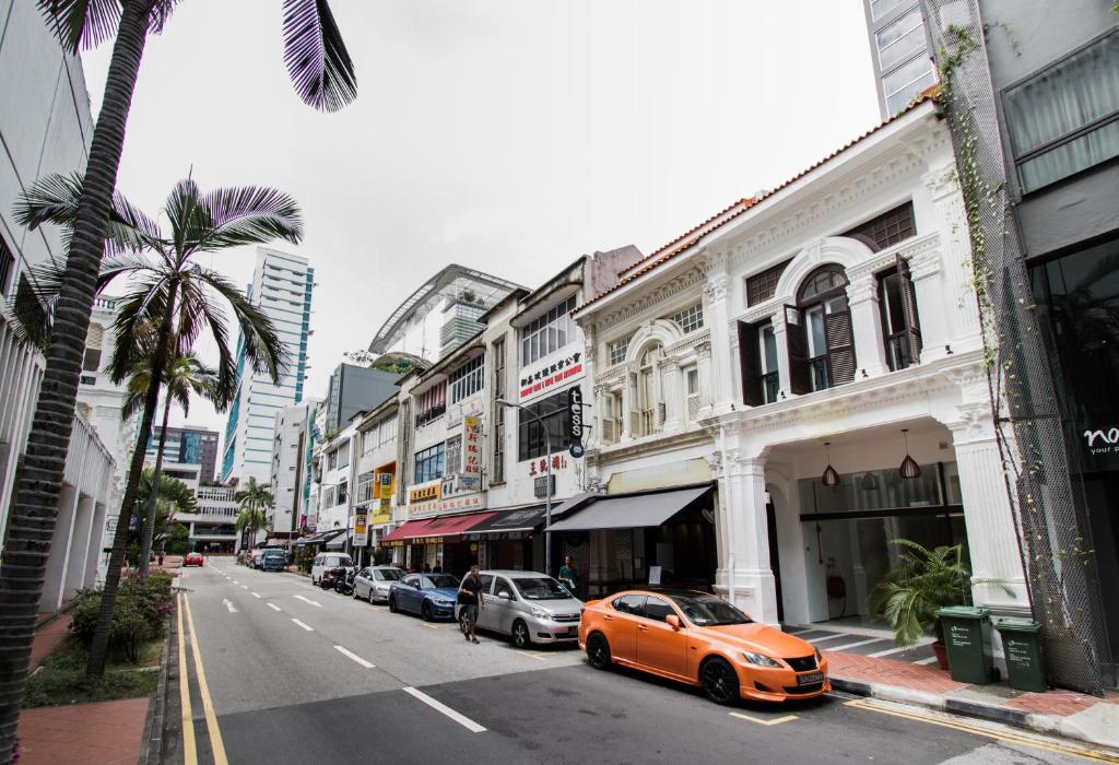 新加坡Heritage Collection on Seah - A Digital Hotel的停在城市街道上的橙色汽车,有建筑