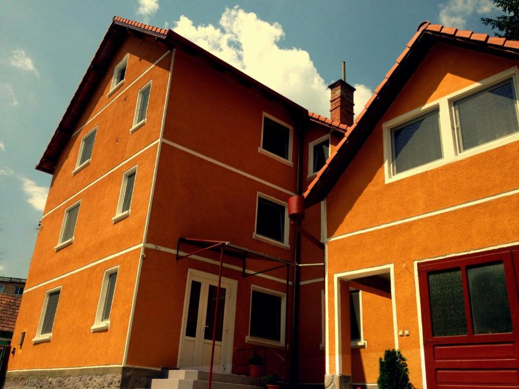 圣格奥尔基Pensiunea Bobo Panzio的一座红色门的大型橙色建筑