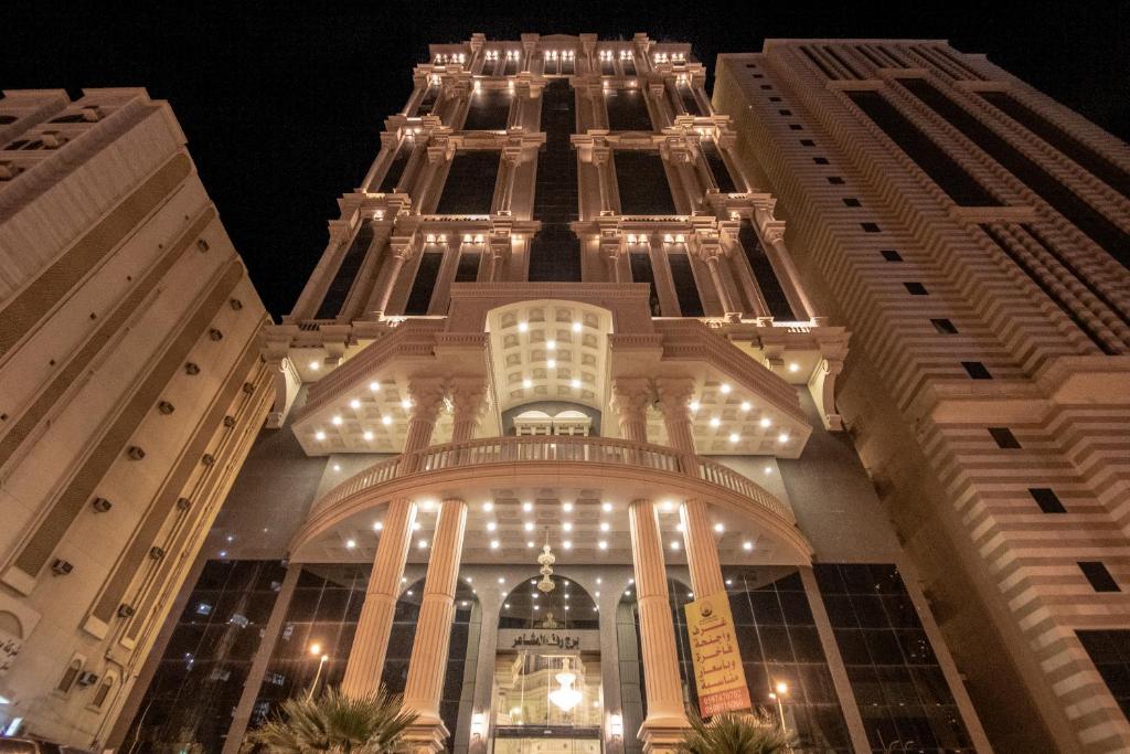 麦加EWG Rahaf Al Mashaer Hotel的一座高大的建筑,晚上有灯