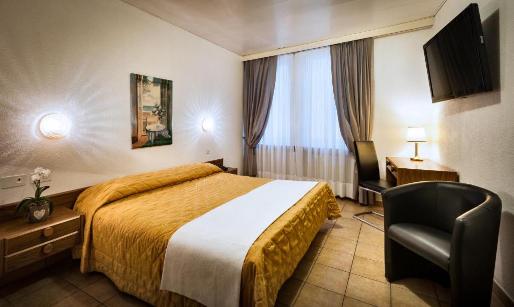 洛迦诺黛尔安格洛酒店的配有一张床和一把椅子的酒店客房
