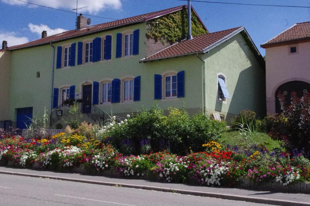 Racrange长老会住宿加早餐酒店的前面有蓝色窗户和鲜花的房子
