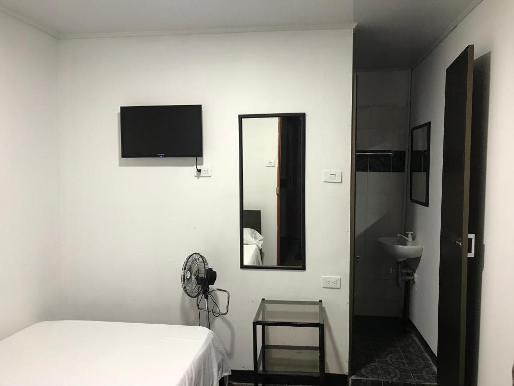 马尼萨莱斯Residencias la Marquesa 2的一间卧室配有床、镜子和水槽