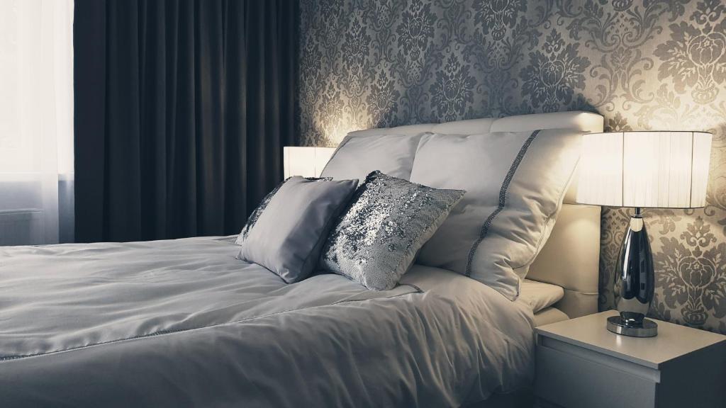 皮拉Silver Apartaments的卧室配有白色的床和2个枕头