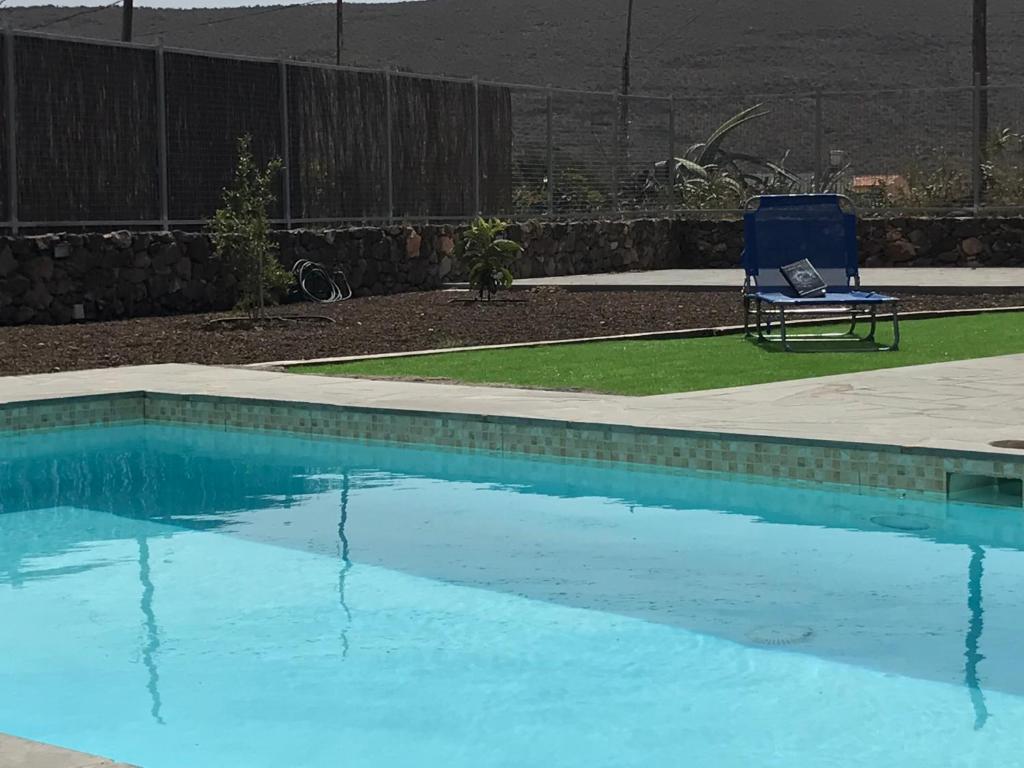 阿古伊梅斯Casa de Los Alberconcillos的游泳池旁的蓝色椅子