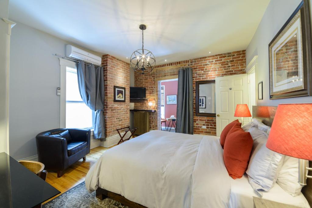 魁北克市双狮酒店的卧室配有白色大床和砖墙