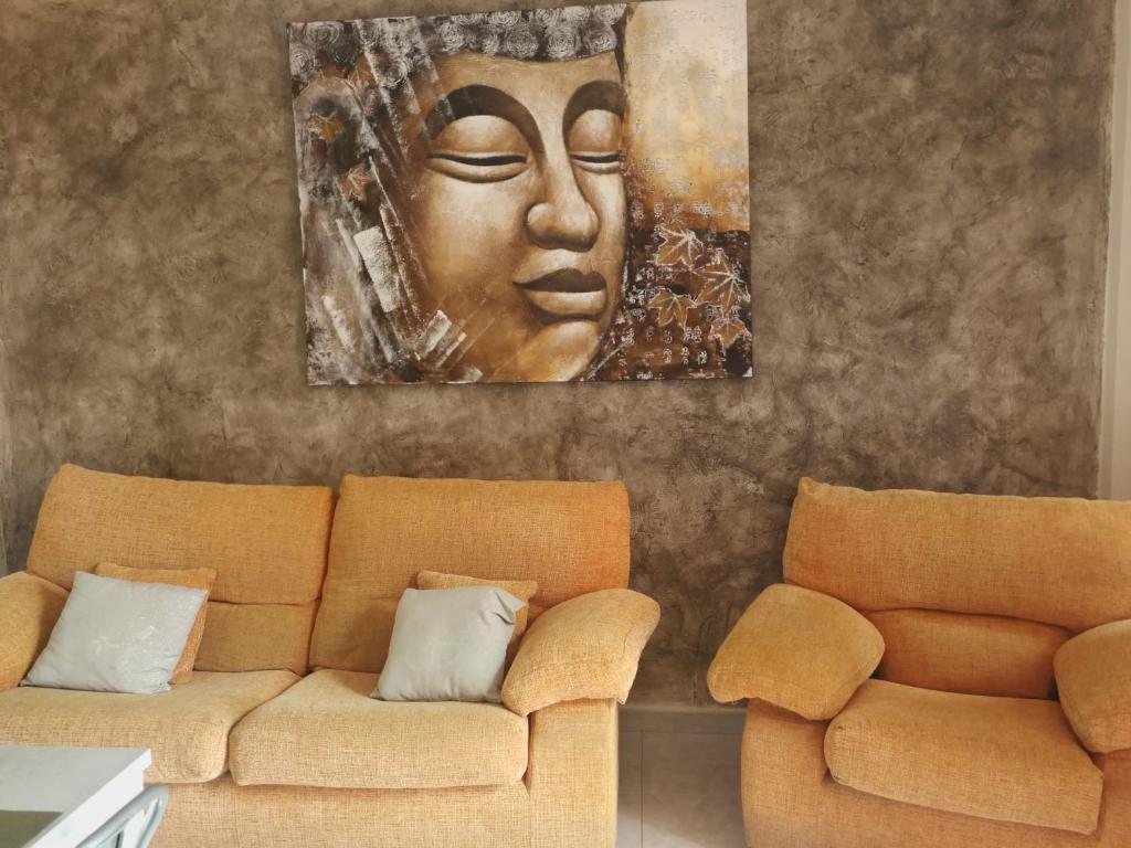 圭马尔港Atico Puertito de Guimar的客厅配有沙发和墙上的绘画