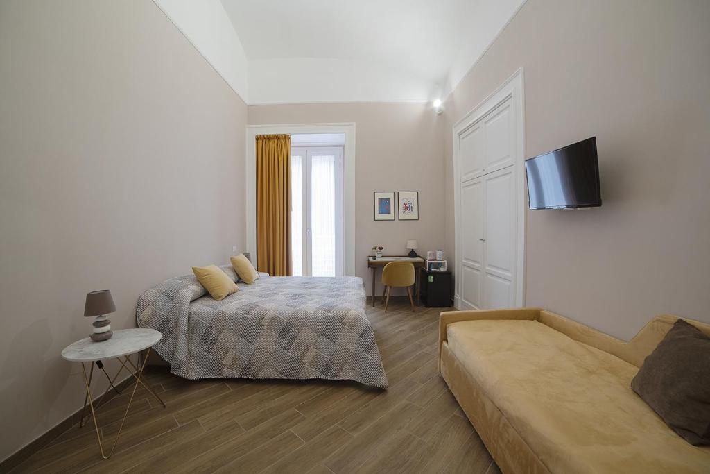 那不勒斯B&B Galleria Principe di Napoli的一间卧室配有一张床和一张沙发