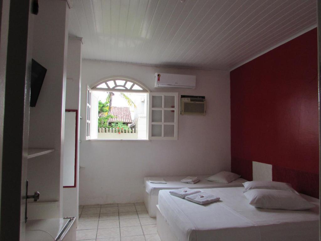 阿尔科巴萨Pousada Pé de Caju的客房设有两张床和窗户。