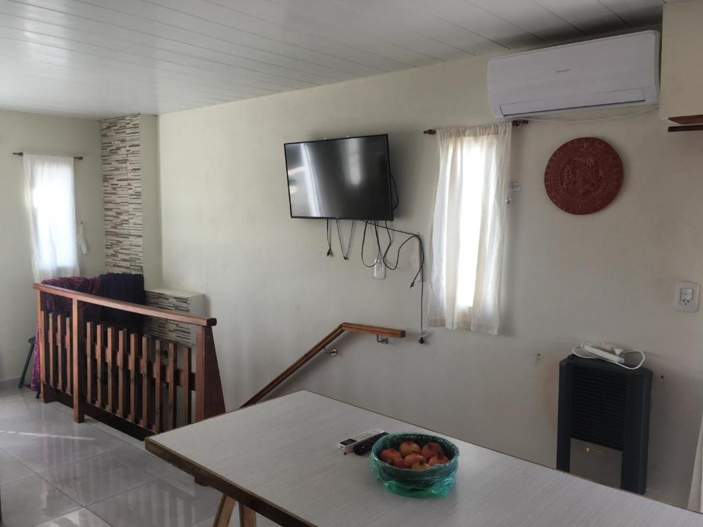 奥拉瓦里亚Hermoso loft con balcón y terraza的一间房间,墙上设有一张桌子和一台电视机