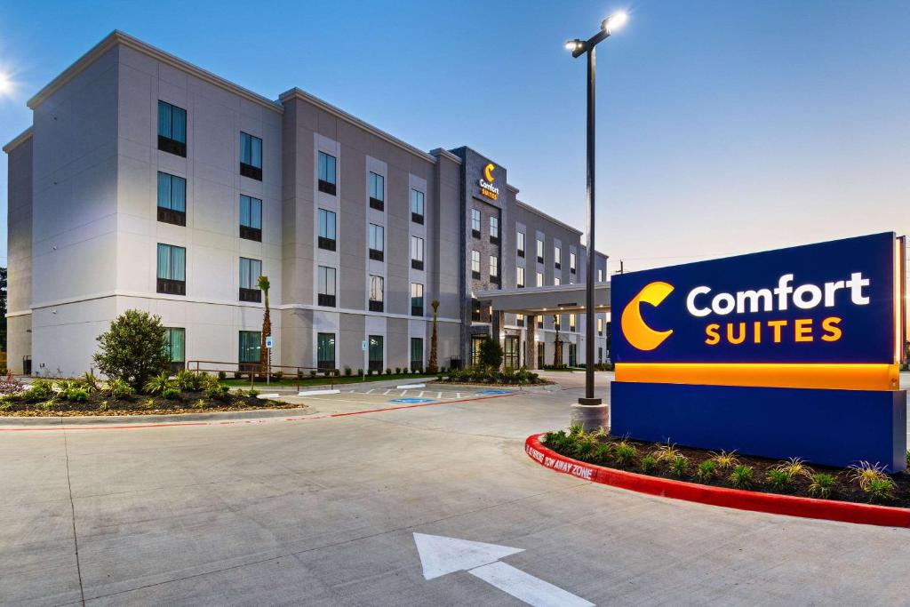 亨博尔Comfort Suites Humble Houston IAH的大楼前的酒店标志