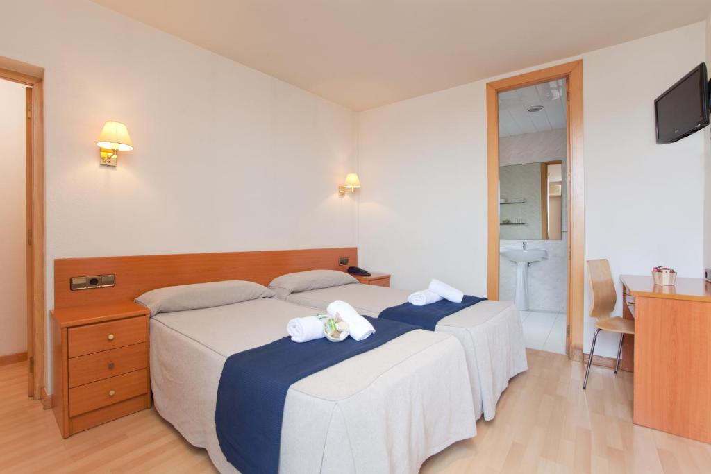 巴塞罗那珠穆朗玛酒店的一间卧室配有两张带毛巾的床