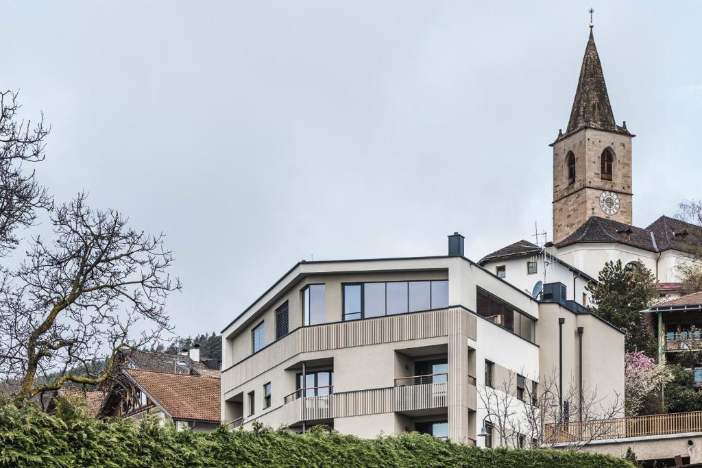 圣杰内肖阿泰西诺Luis & die Buabm - Gasthof Jenesien的一座带钟楼和教堂的建筑