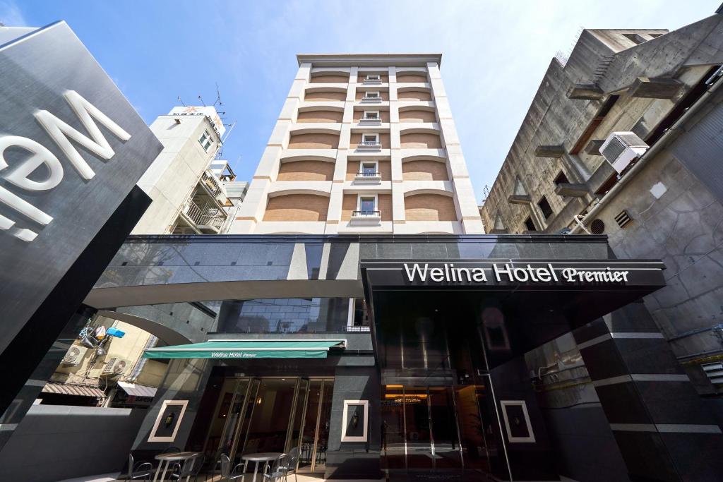 大阪Welina Hotel Premier Shinsaibashi的前面有酒店标志的建筑