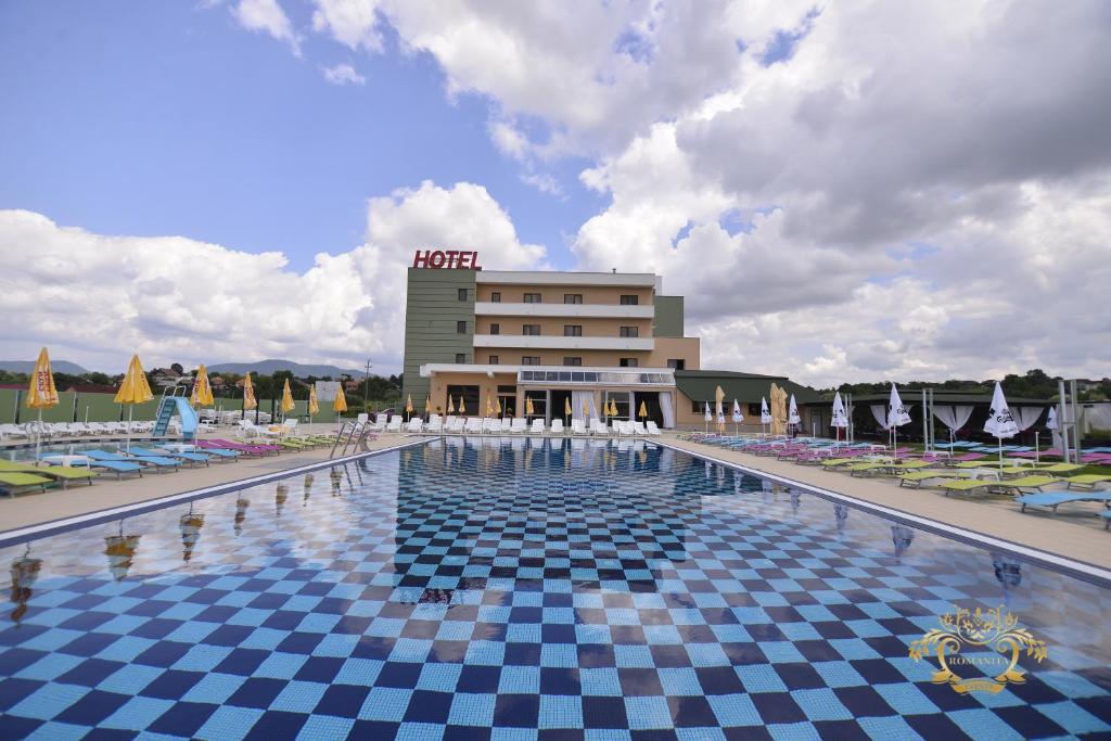 巴亚马雷Hotel Romanita的一座带椅子的游泳池和一座建筑
