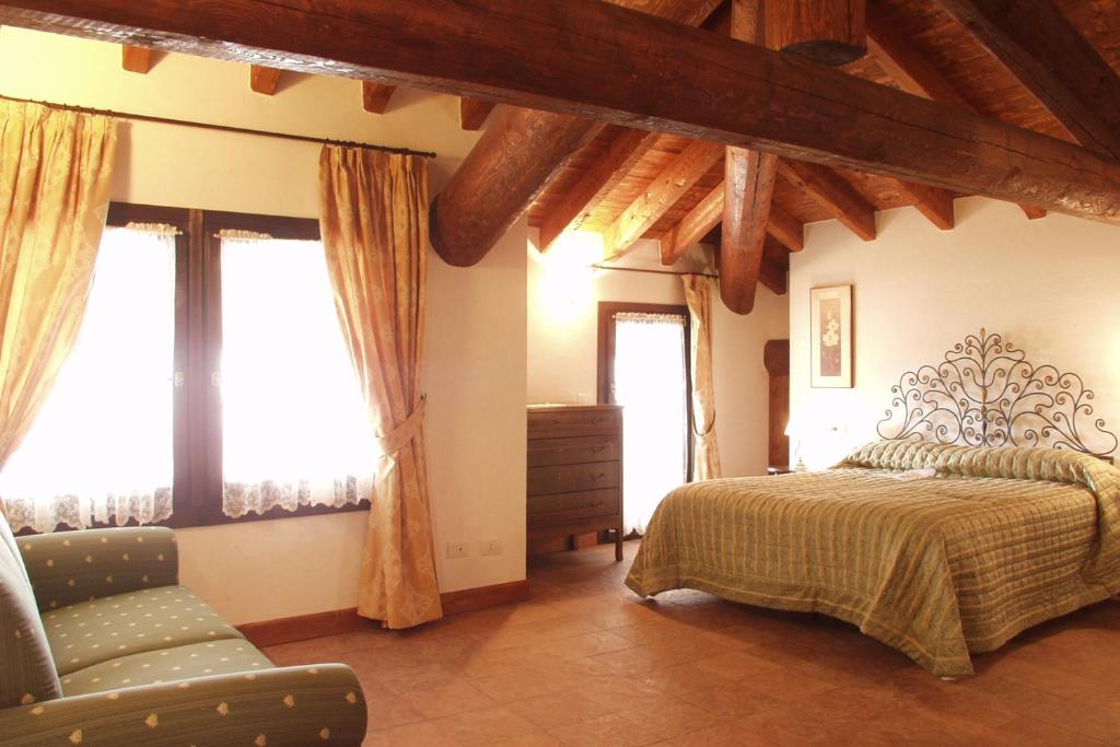 博尔诺Bed and Breakfast Zanaglio的一间卧室配有一张床、一把椅子和窗户。
