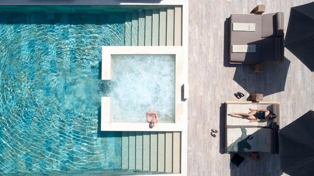 科斯镇兰戈设计酒店及水疗中心 - 仅限成人入住的游泳池的顶部景观,有两人坐