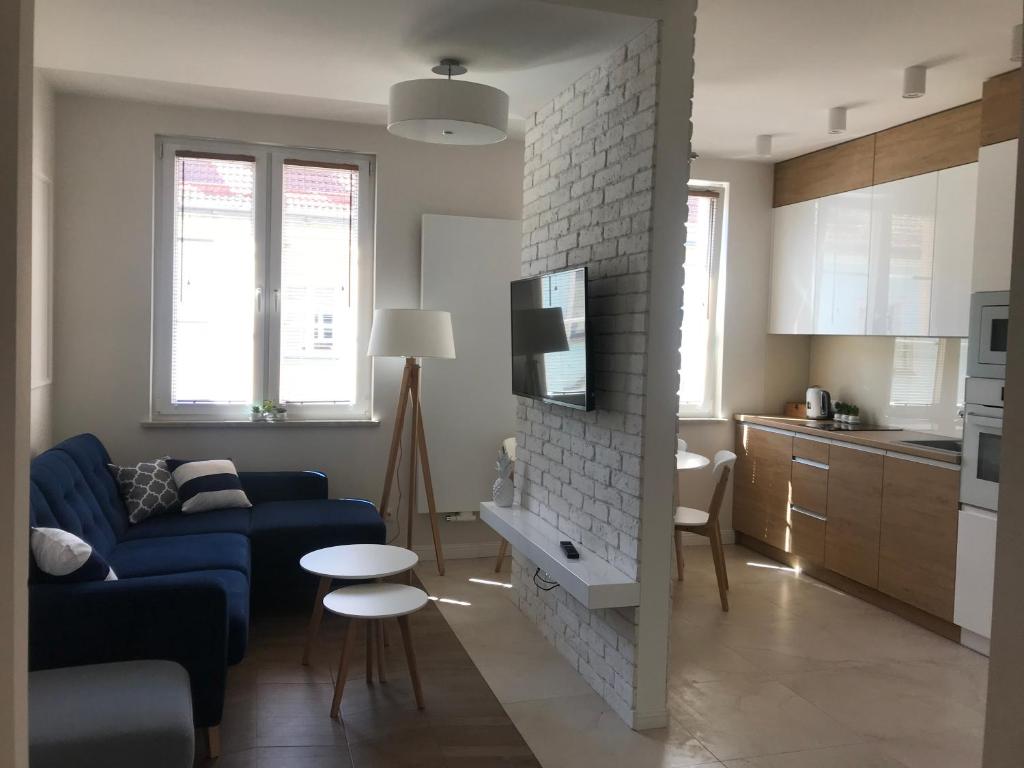 奥普尔Apartament w samym sercu Opola的一间带蓝色沙发的客厅和一间厨房