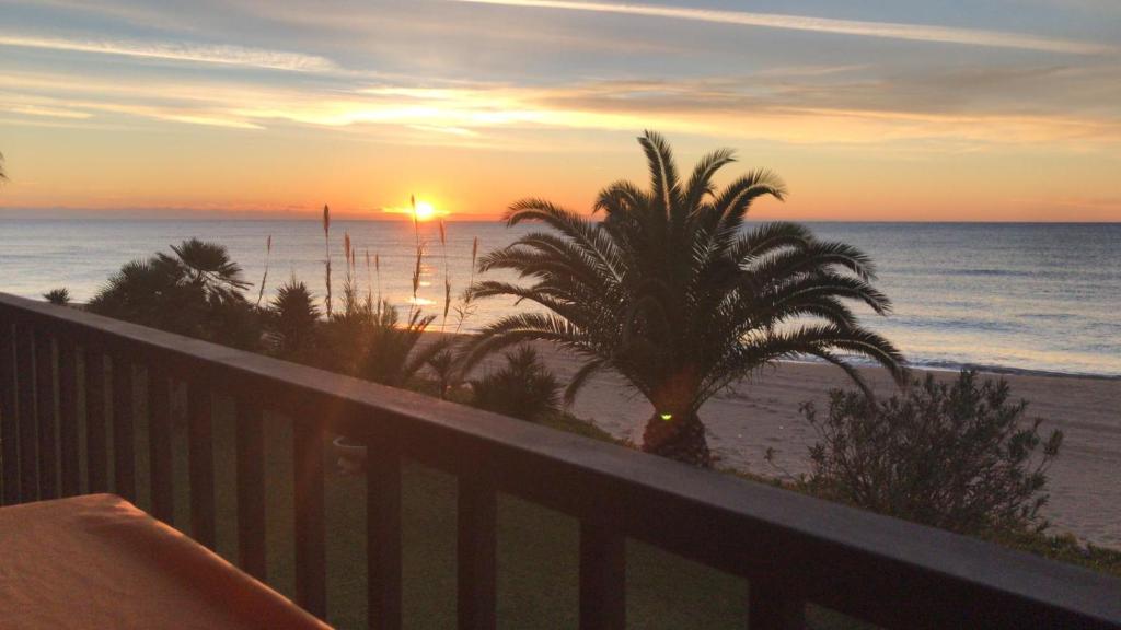 科马鲁加Paraiso frente al mar Apto duplex的从度假村的阳台欣赏日落