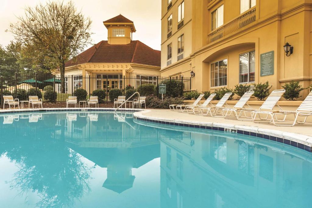 亚特兰大亚特兰大棒球场/拱廊拉金塔旅馆及套房酒店的酒店游泳池设有椅子,酒店大楼
